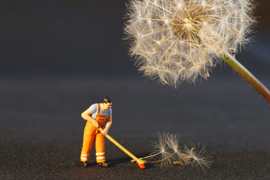 shallow focus photo of man holding floor brush ceramic figurine